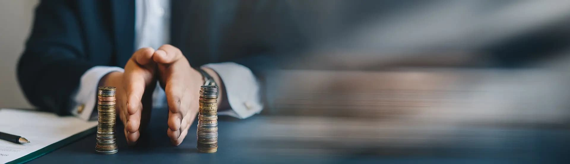 Hand mit aufgestapelten Geldmünzen